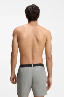 Badeshorts mit kontrastfarbenem Logo und Paspelierung